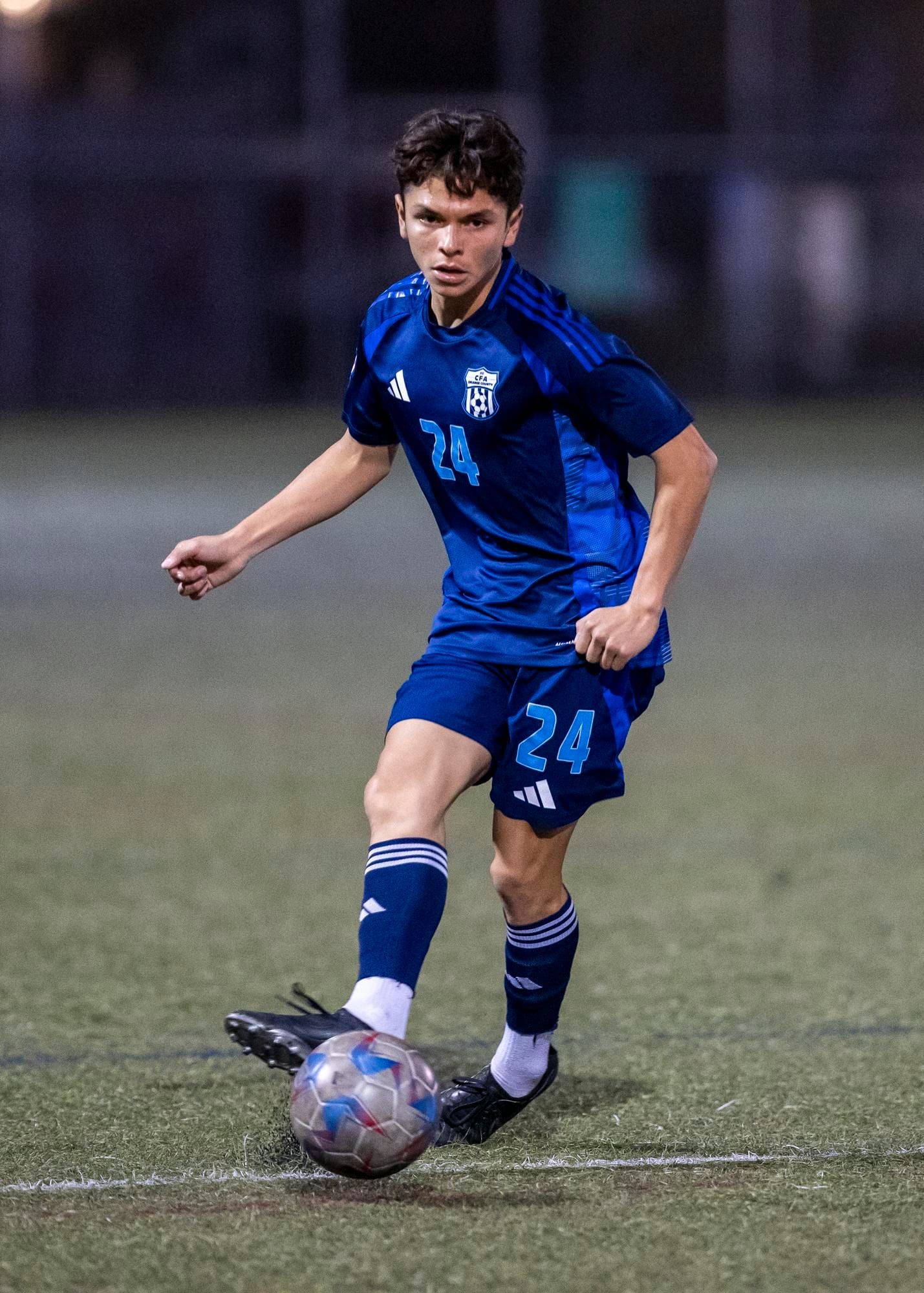 CFA boys player in navy bringing the ball forward