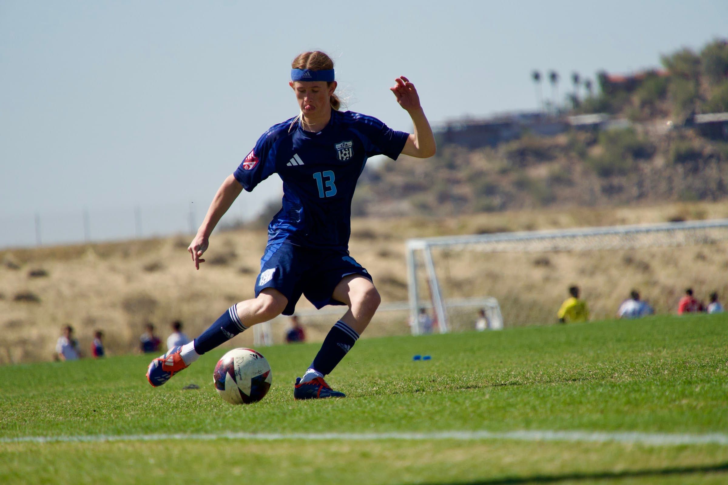 CFA boys player in navy about to strike the ball