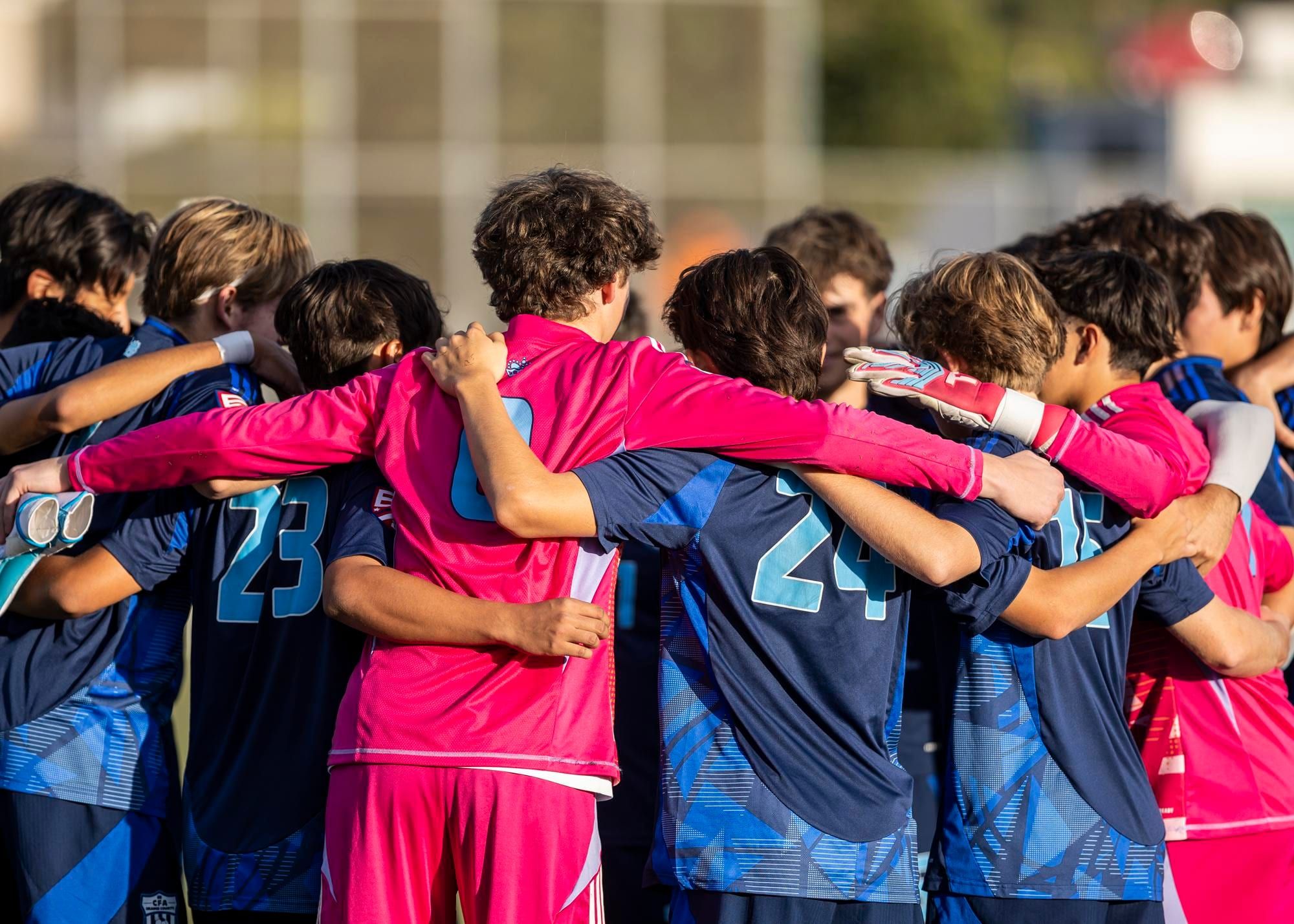 CFA boys team in a tight huddle before kickoff