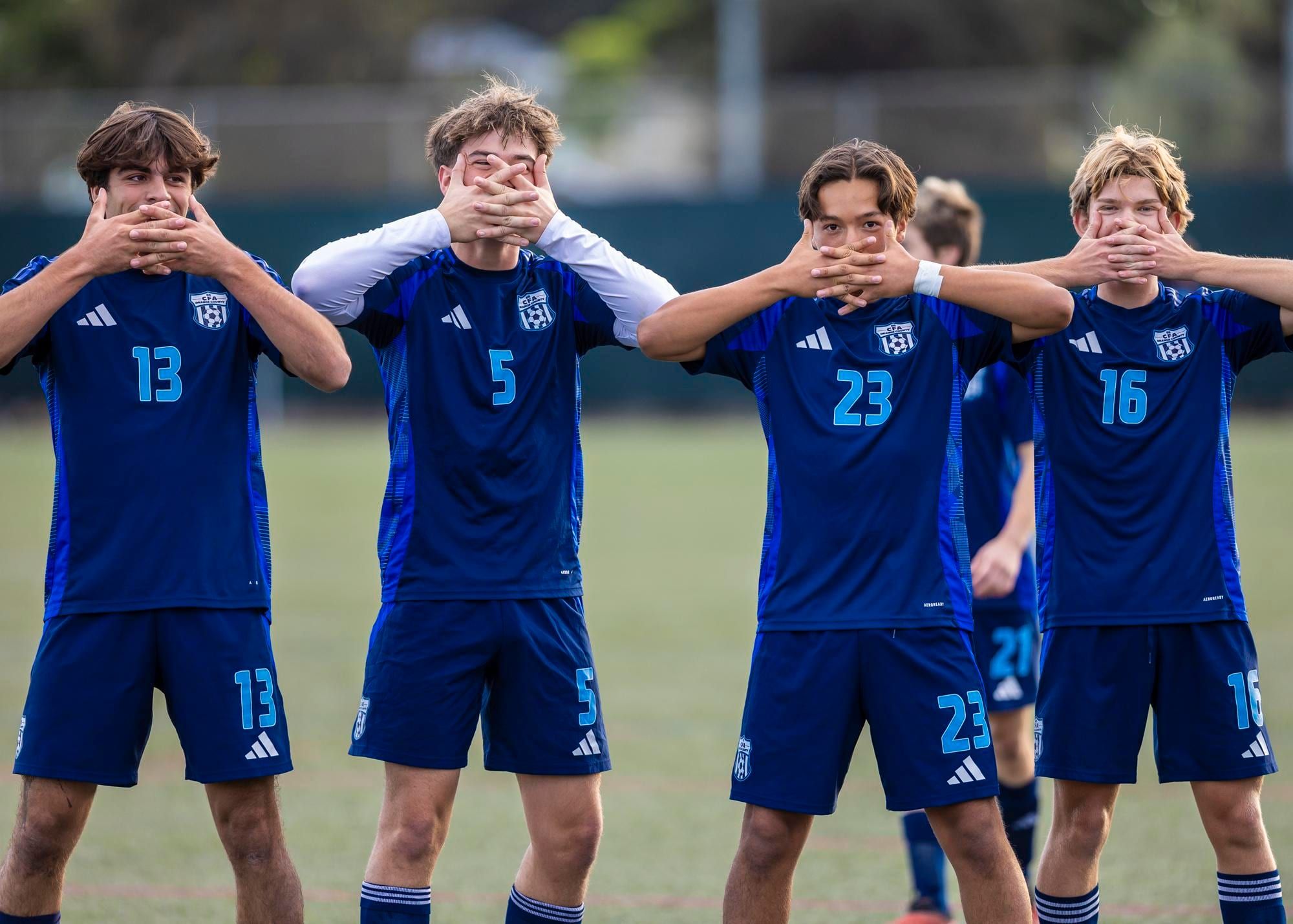 CFA boys in navy kits posing together on the field