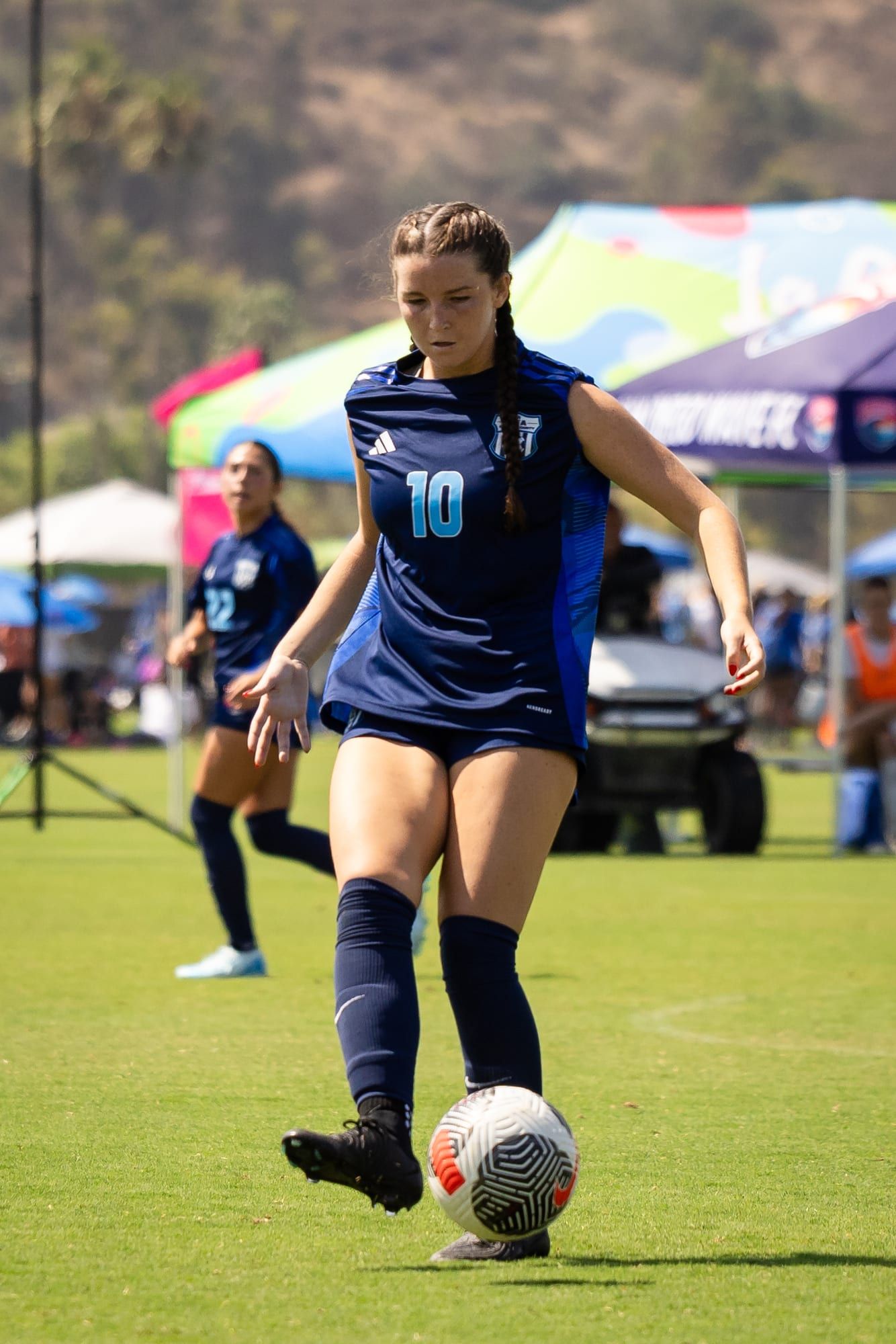 CFA girls player in navy dribbling at a tournament