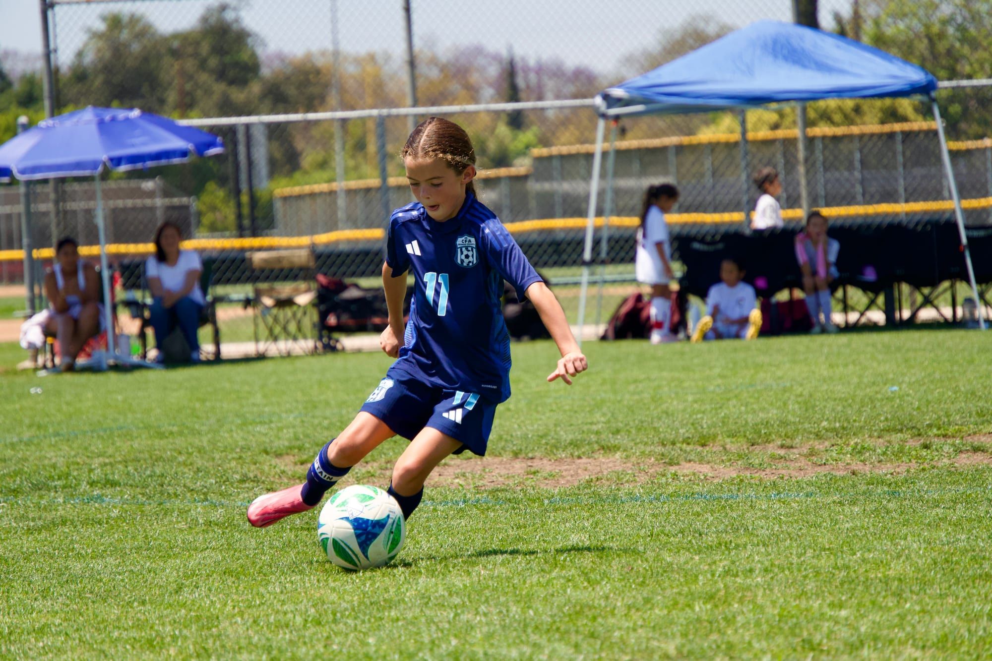 CFA girls player in navy striking the ball