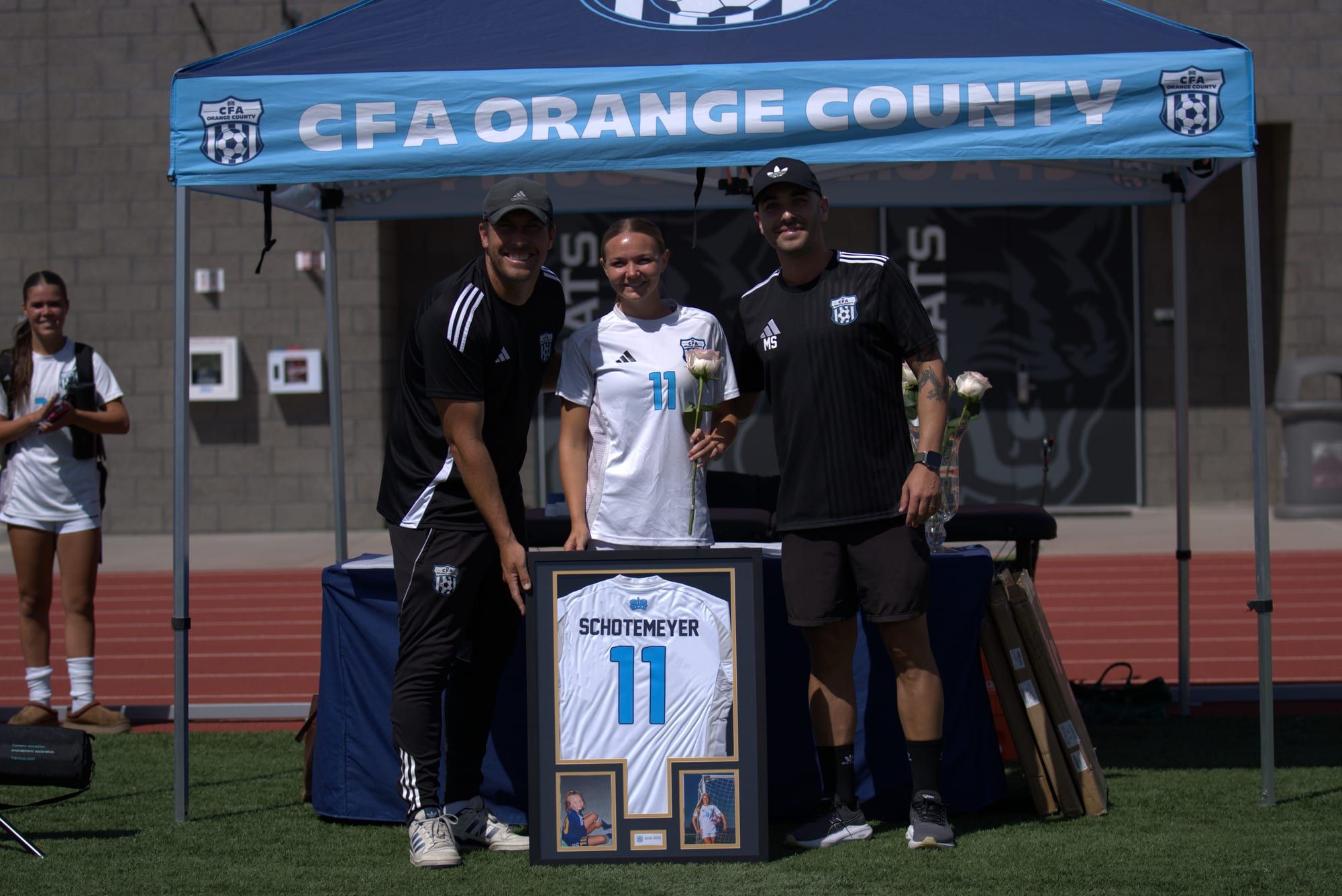 CFA senior with coaches and a framed club jersey at the senior celebration
