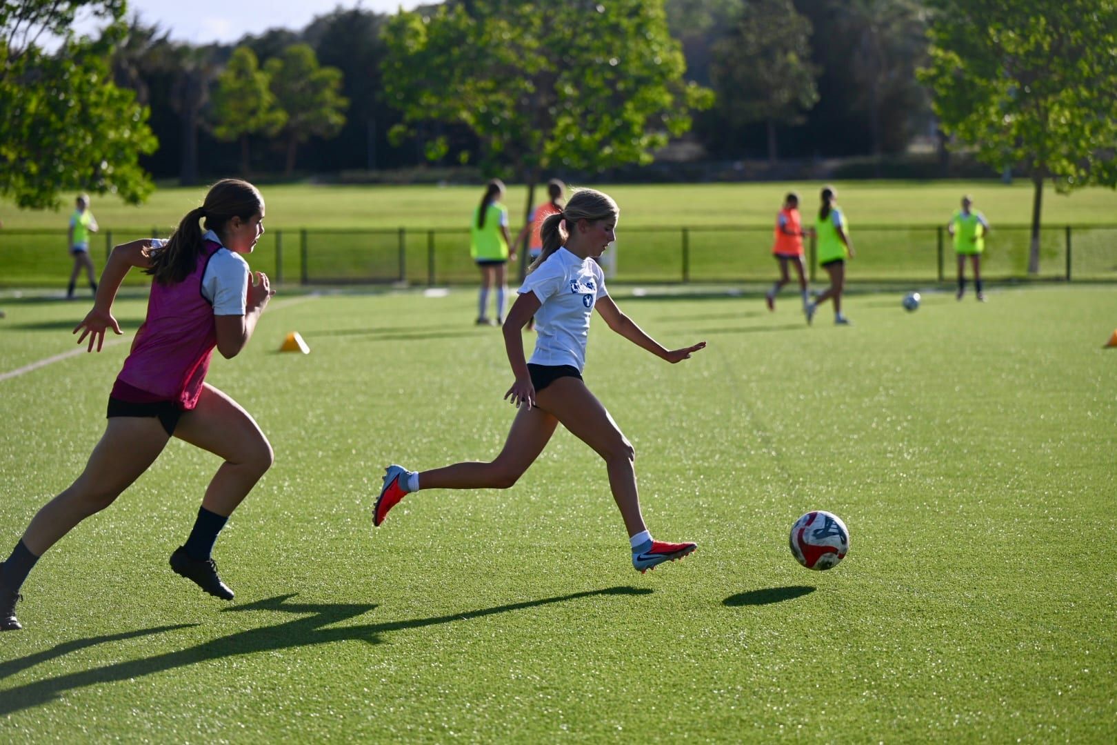 Players sprinting after the ball at CFA tryouts